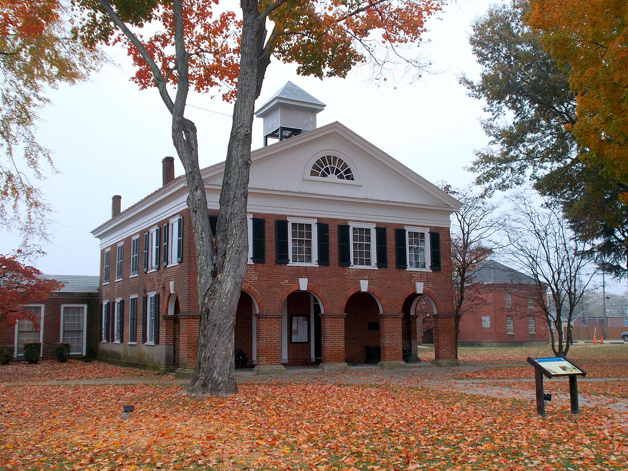 Brick Caroline County Courthouse framed by autumn trees