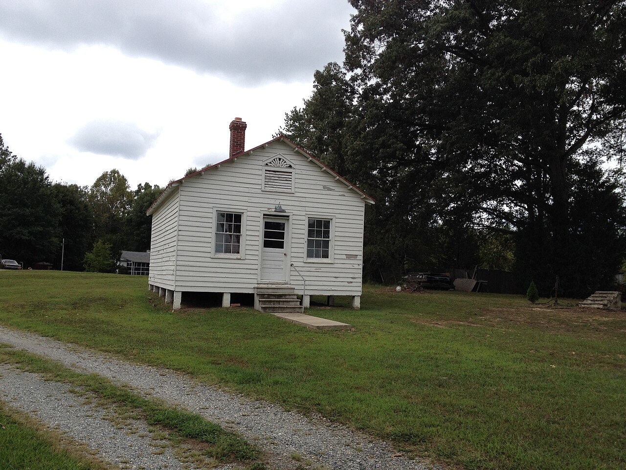 White wooden Jericho School beside a gravel drive