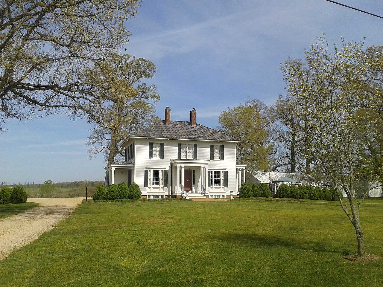 White two-story Winterham house beside a curving gravel drive