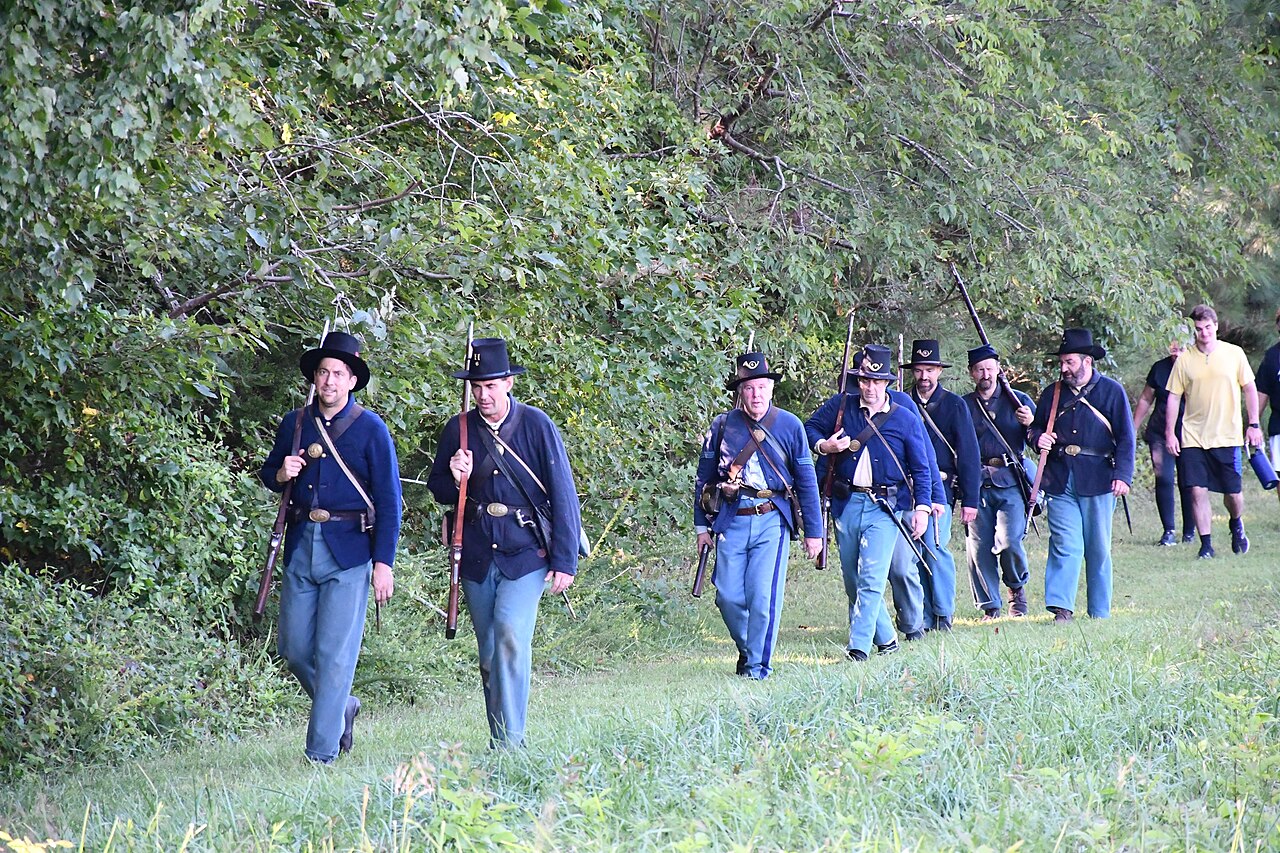 Living-history volunteers in blue uniforms leading a hike at Five Forks
