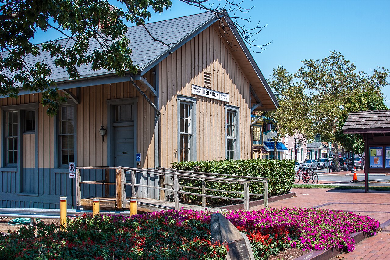 Herndon Depot beside flowers and a paved path
